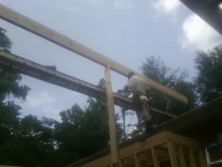 Carpenter setting a ridge beam over a new addition frame — Ice Dam Removal by Roofing Brothers in Northbrook