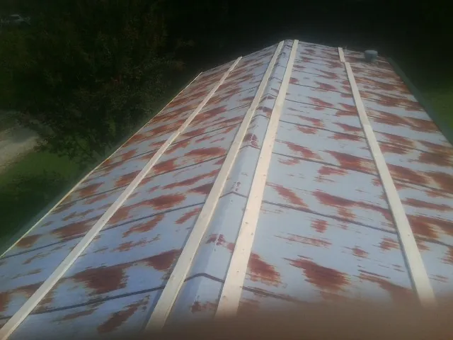 Rusted metal roof panels with new wood purlins before replacement — Storm Damage Roof Repair in Northbrook by Roofing Brothers