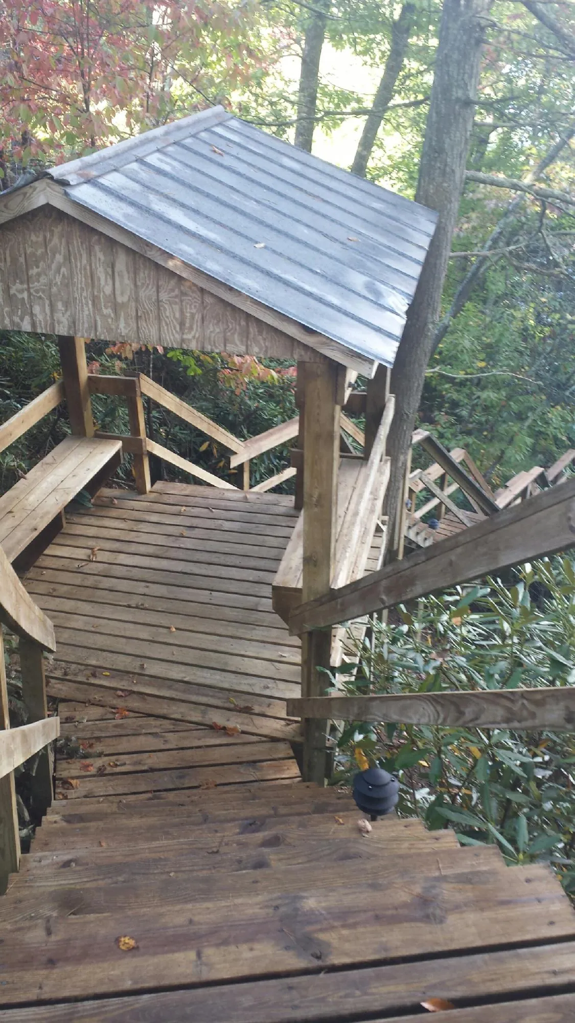 Metal roofed shelter over wooden steps on a wooded walkway — Skylight Repair & Installation work by our crew in Northbrook