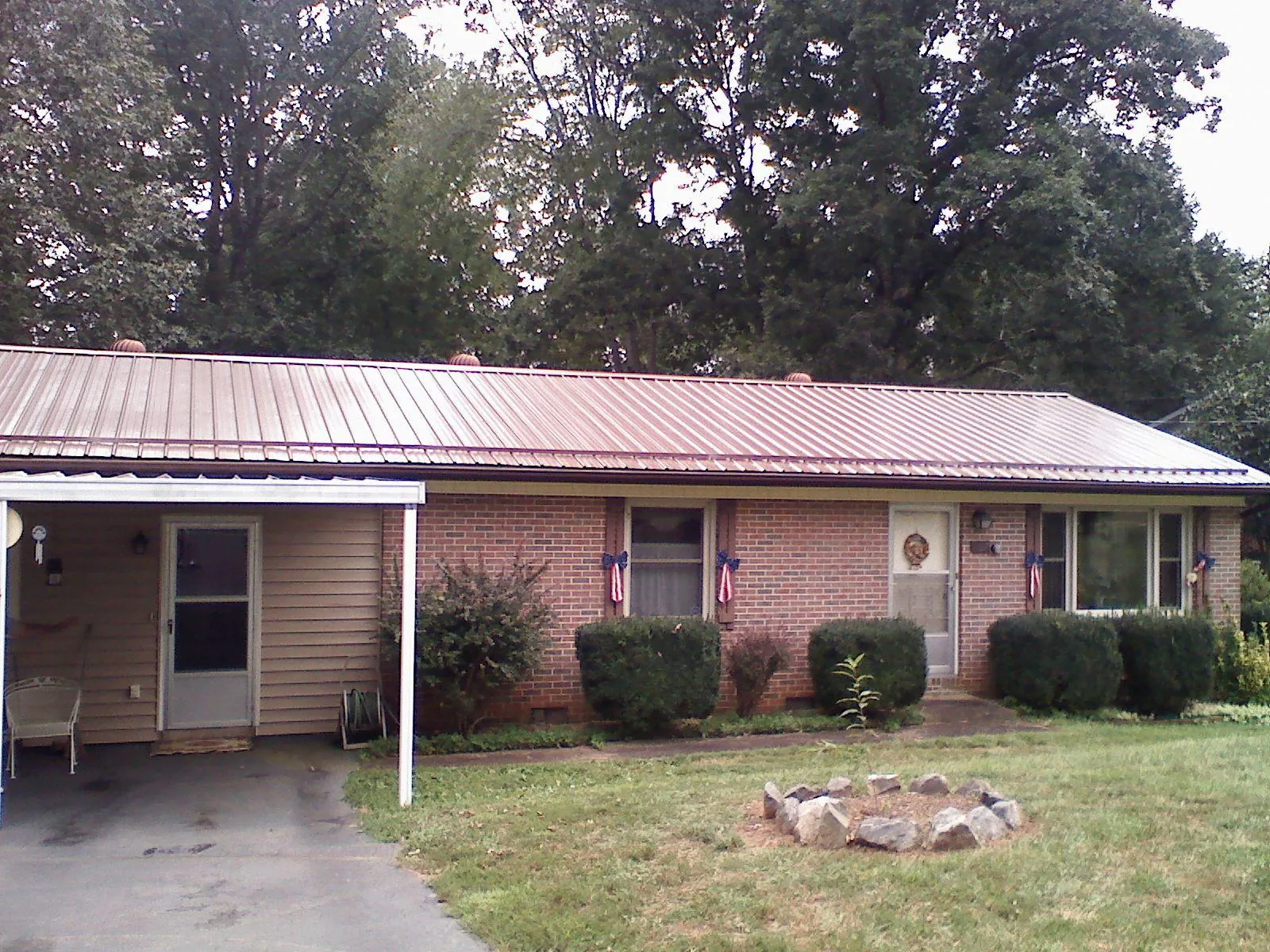 Bronze metal roof and carport on a brick ranch home — Roof Repair work by our crew in Northbrook